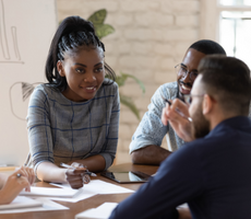 three people talking in a conference room