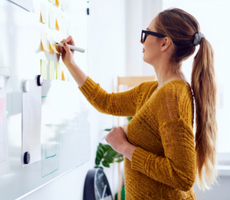 woman writing notes on a whiteboard