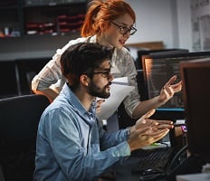 two people writing code on computers