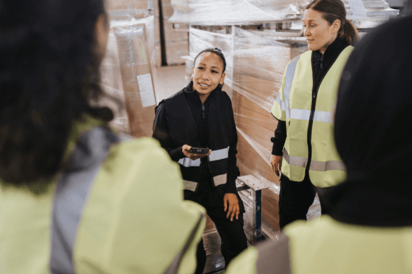 Frau im Lager mit Kollegen arbeitet für Amazon Vendor Central Programm