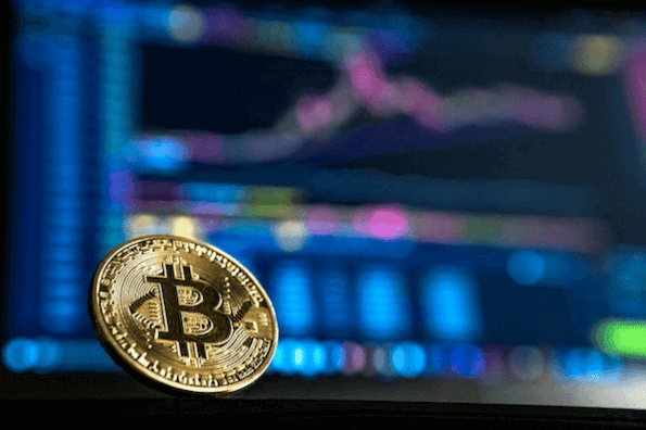 Bitcoin-Geldmünze vor Computerbildschirm 