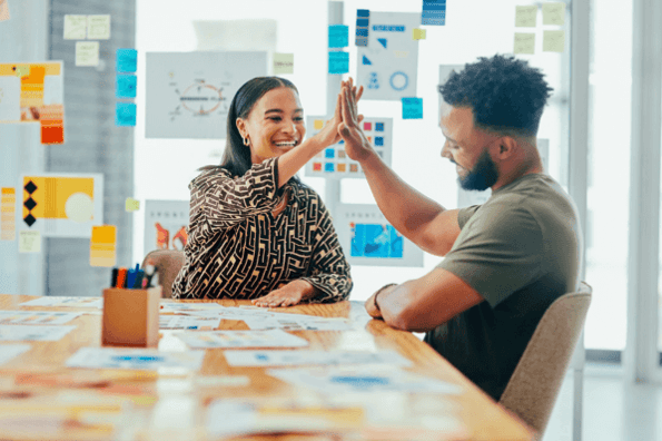 Mann und Frau erstellen Branded Content und geben sich High Five 