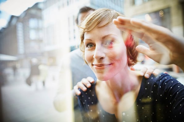 Frau blickt ins Schaufenster eines Flagship-Store