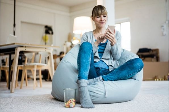 Frau auf Sitzsack erstellt Instagram-Avatar auf Handy