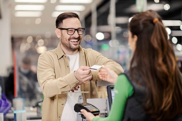 Kunde freut sich über Kundenbindung beim Einkaufen an der Kasse