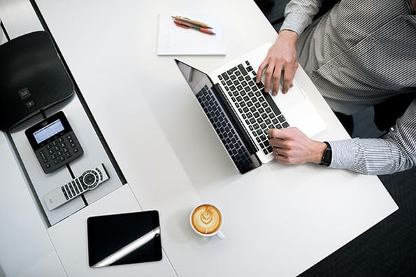 Person am Laptop auf Tisch arbeitet mit PaaS