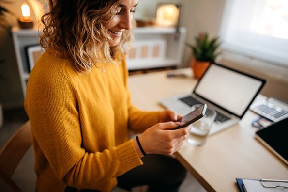 Frau mit Smartphone in Hand liest Artikel über Soft Bounce vs. Hard Bounce