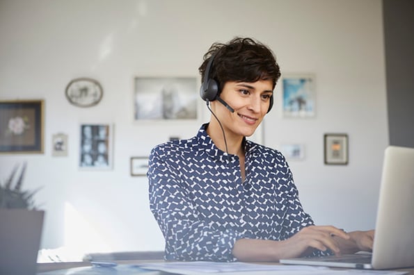 Frau telefoniert mit Headset über VoIP