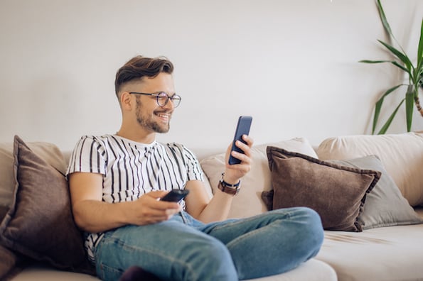 Consumer using multiple screens to watch TV and check email