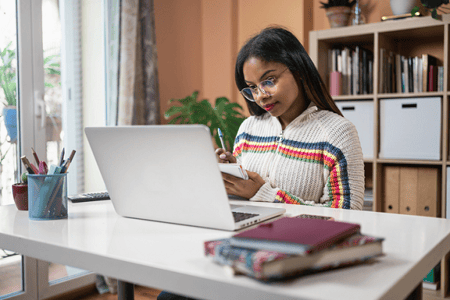 Young woman using her computer to study Python multiprocess, how they work and how to use them.