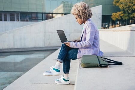 Woman at a park studying React props to improve her programming knowledge.