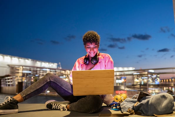 person looking a brutalist website desgins on a laptop outside in a city setting