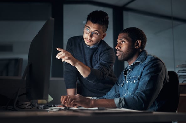 two people discussing ecommerce fraud protection at a computer