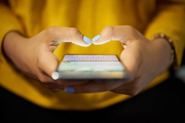 A woman using her mobile device to interact with bootstrap cards, discovering how useful they can be.