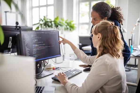 two people using a desktop computer to write code with the html a href attribute