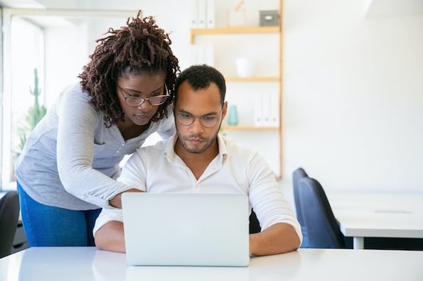 two people using a computer to park a domain name