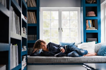 woman reading a magazine purchased from a magazine wordpress theme in a home library 