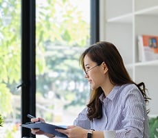 person writing on a digital tablet