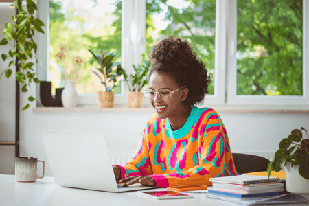 Young woman excitedly learning about the differences between PHP and HTML for her web development.