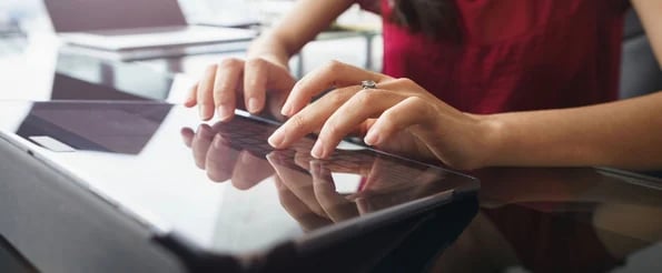 person typing on tablet using personal assistant tools