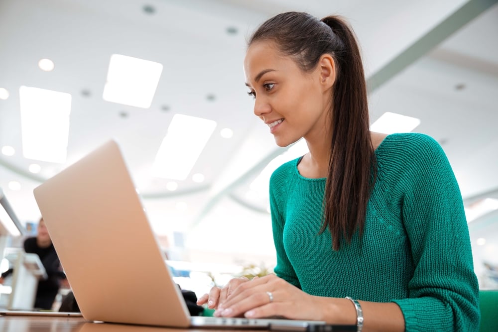 Portrait of a happy female using laptop