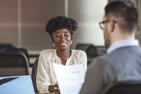 confident candidate presenting her sales manager resume to a recruiter