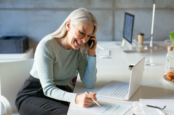 representante-de-vendas-mulher-fala-ao-telefone-enquanto-faz-anotações 