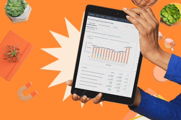 A person holds up an tablet showing a graph, representing marketing attribution. 