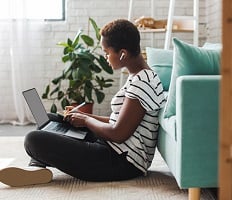 person sitting on the floor using a laptop