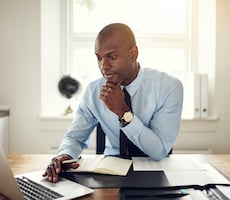 man using a computer at a desk