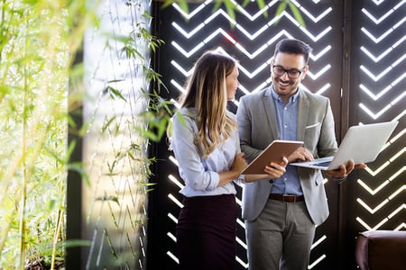 Two coworkers weighing the advantages and disadvantages of spreadsheets