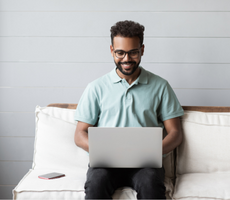 person sitting on a couch with a laptop