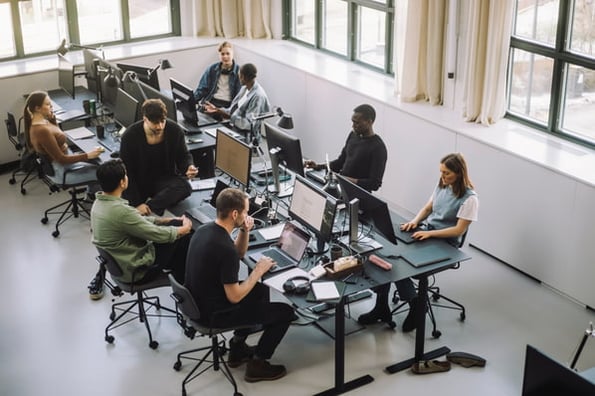 Developers sitting together at their desks in an office backend testing. 