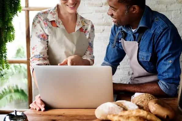 two bakers using a laptop to create a bakery website