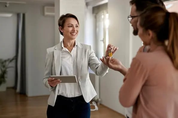 A successful real estate agent handing over the keys to a new home. 