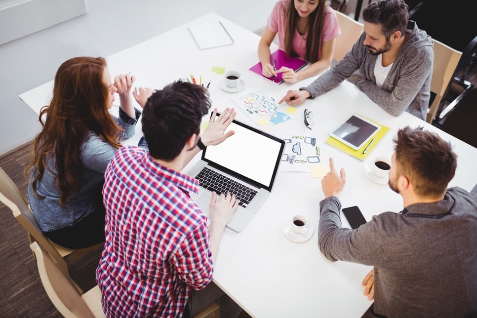 High angle view of young partners discussing in meeting room at creative office