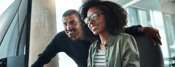 two people using a computer and smiling