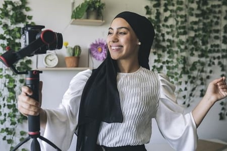 A woman films a video as part of the creator economy. 