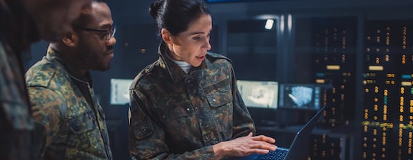 people using a laptop in a server room