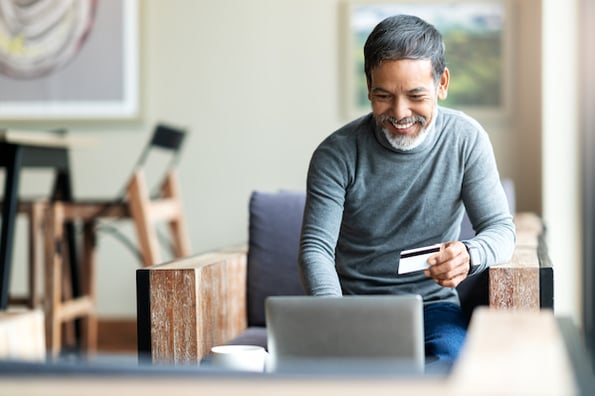 man submitting a donation form template with a laptop and a credit card