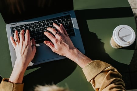 a person received an email to their laptop while they enjoy a cup of coffee; email automation