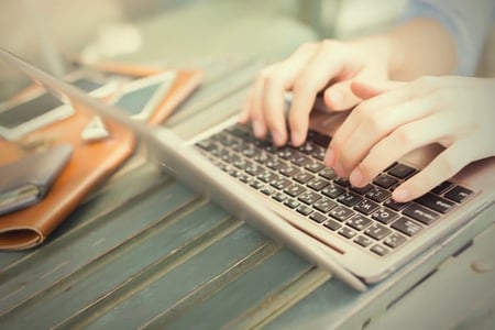 blogger typing writing tips on a laptop