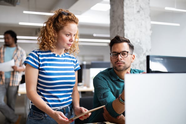 two developers browsing for free open apis on a computer in an office