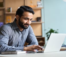 man using a laptop at a desk