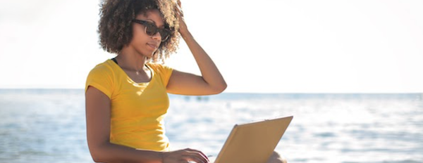 person using a laptop on a beach