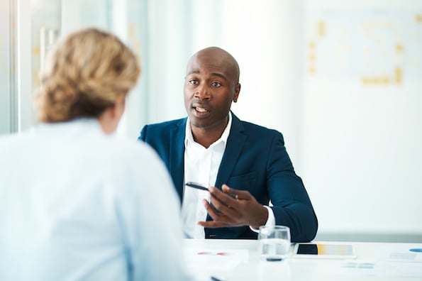 Two salespeople discussing how they can increase sales