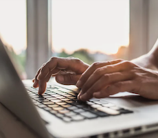 hands typing on a laptop