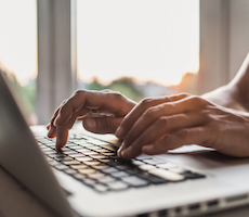 hands typing on a laptop