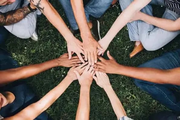 image of many hands piled on top of each other showing inclusive-marketing 