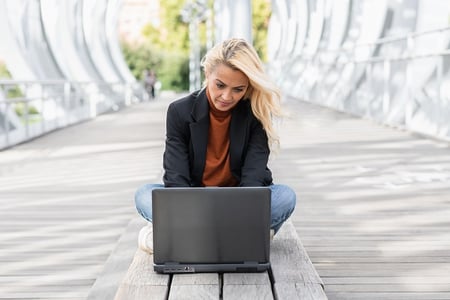 Woman studying Javascript for loops on her computer in the park.